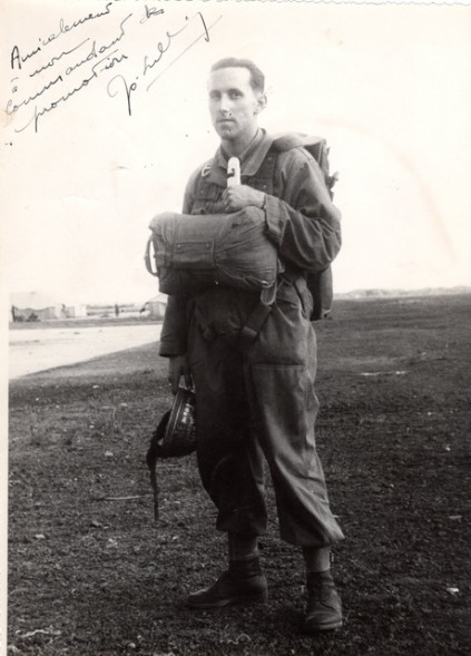  parachutiste , mousqueton de SOA en main gauche ,tient un casque d'entrainement modèle 1945 couvert d'inscriptions par grattage de la peinture .Cet usage était assez repandu .On trouvait des noms , des prénoms féminins , des extraits de chansons , des numeros d'unité ..etc.....ainsi gravés .Il porte une combinaison de saut