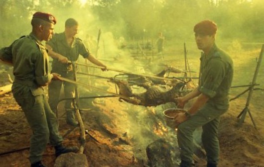 Les moutons sont arrosés au moyen d'un chiffon fixé au bout d'une perche et trempé régulièrement dans un récipient contenant un assaisonnement adapté Les moutons sont arrosés au moyen d'un chiffon fixé au bout d'une perche et trempé régulièrement dans un récipient contenant un assaisonnement adapté